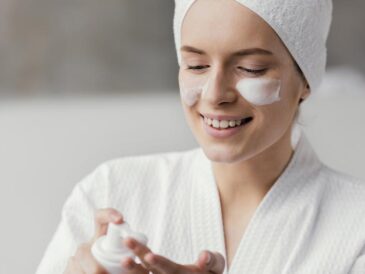 Kvinna med ansiktskräm på kinden