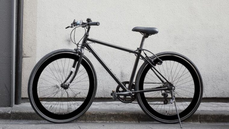 En låst cykel intill en vägg